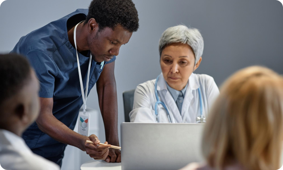Healthcare workers discussing results around a laptop